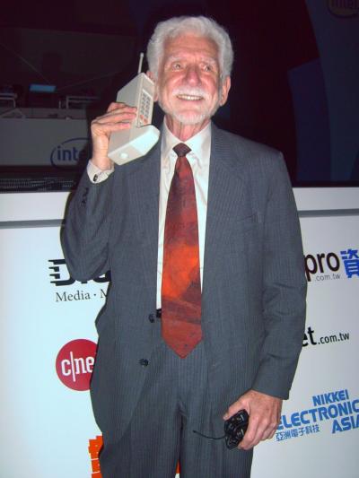 Martin Cooper holding a prototype handheld phone