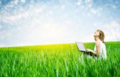 Girl in fields holding a laptop